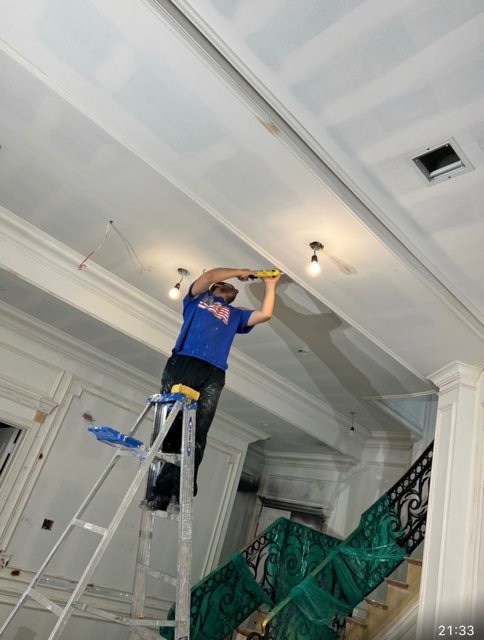 Technician taping and finishing a ceiling during renovation