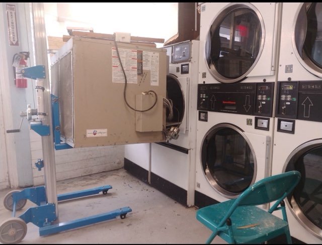 Commercial laundry equipment being installed with an appliance dolly